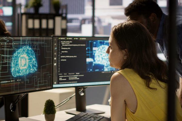 Employee using AI technology to design algorithms that enable machines to learn from data. Admin in office training large scale deep learning models with artificial intelligence tech, camera A