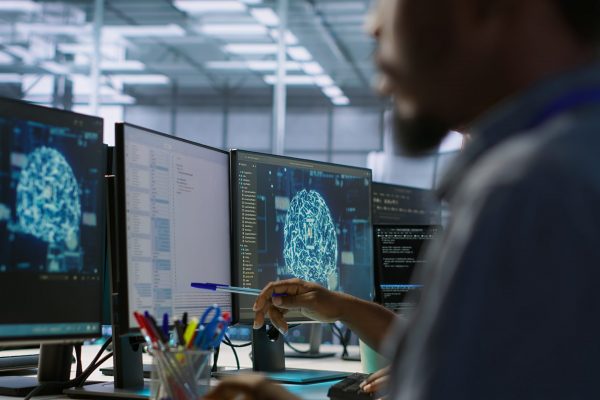 Machine learning expert in data center maintaining company network infrastructure. Worker using artificial intelligence server hub to ensure optimal system performance, camera A